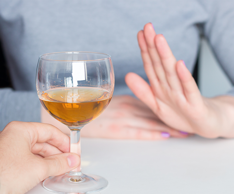 woman refusing a glass of wine