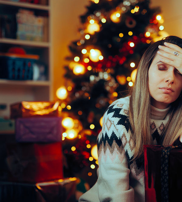 Woman with head in hand dealing with holiday stress