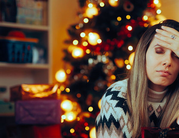 Woman with head in hand dealing with holiday stress